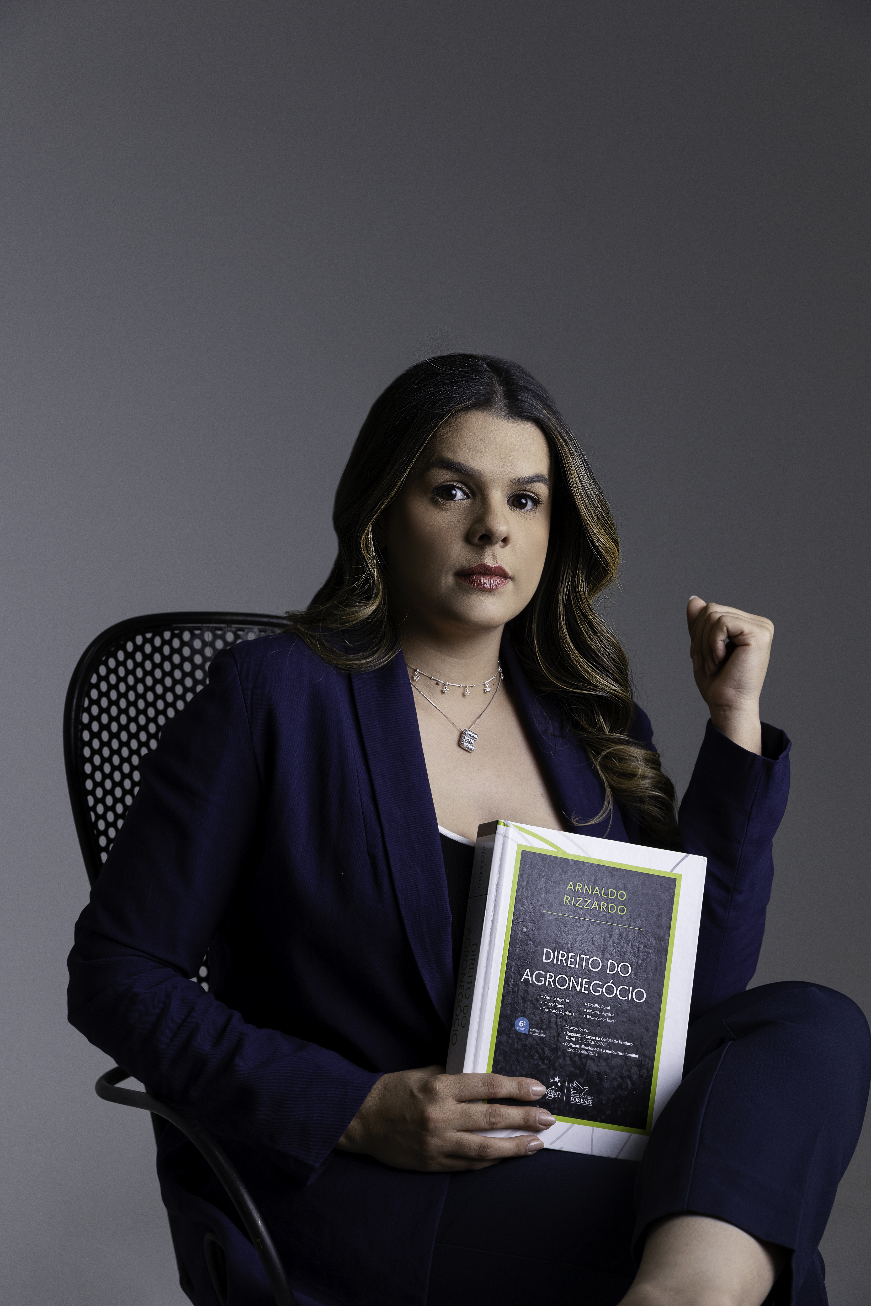 Érica Ferreira sentada com o livro Direito do Agronegócio
